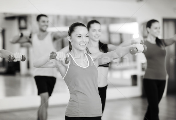 Csoport mosolyog emberek dolgoznak ki súlyzók fitnessz Stock fotó © dolgachov