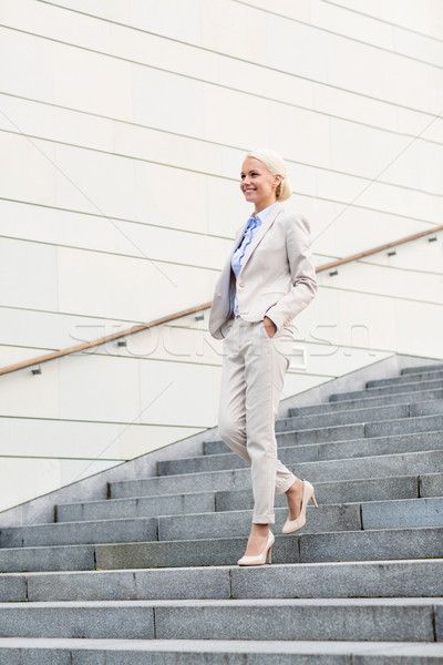 young smiling businesswoman walking down stairs Stock photo © dolgachov