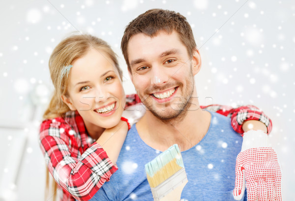 smiling couple with paintbrush at home Stock photo © dolgachov