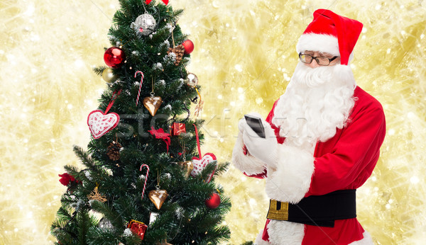 Stock photo: santa claus with smartphone and christmas tree