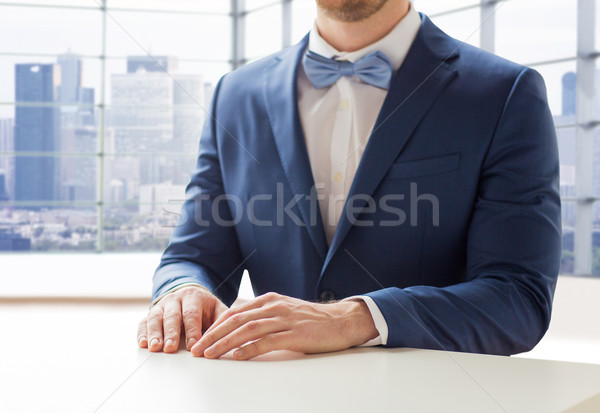close up of man in suit and bow-tie at table Stock photo © dolgachov