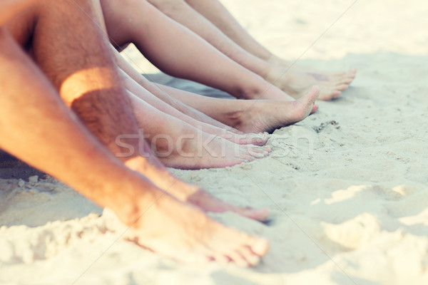 Stock photo: close up of friends sitting on summer beach