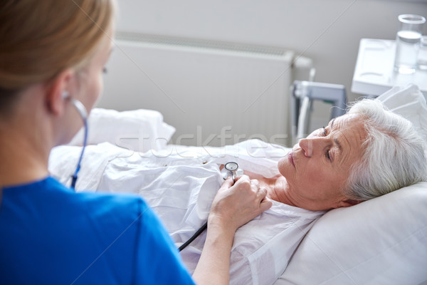 nurse with stethoscope and senior woman at clinic Stock photo © dolgachov