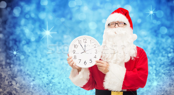 man in costume of santa claus with clock Stock photo © dolgachov