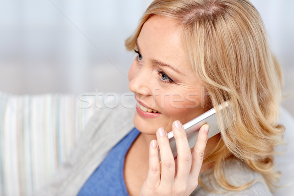 Stock photo: smiling woman calling on smartphone at home