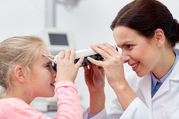 optician with pupilometer and patient at eye clinic Stock photo © dolgachov