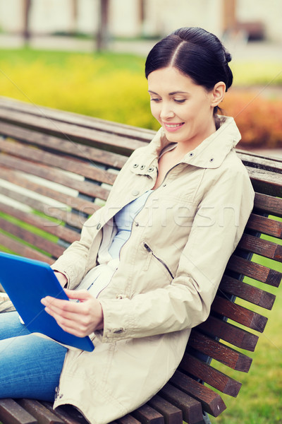 woman with tablet pc sitting on bench in park Stock photo © dolgachov