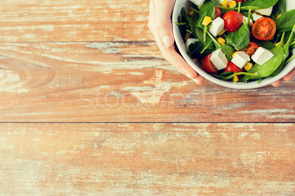 close up of young woman hands with salad bowl Stock photo © dolgachov