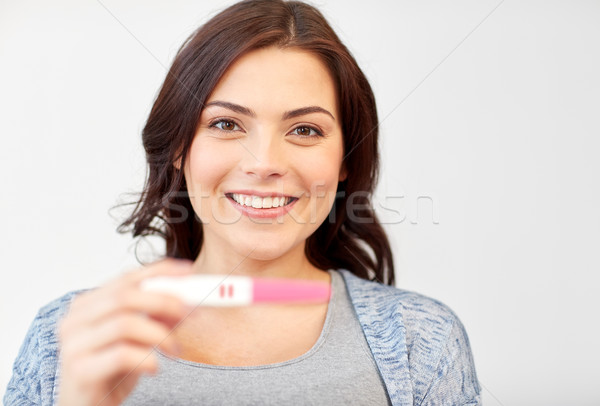 Glücklich lächelnde Frau halten home Schwangerschaftstest Schwangerschaft Stock foto © dolgachov