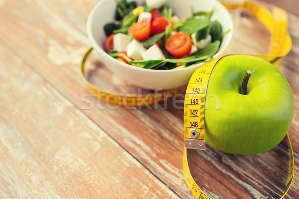 close up of green apple and measuring tape Stock photo © dolgachov