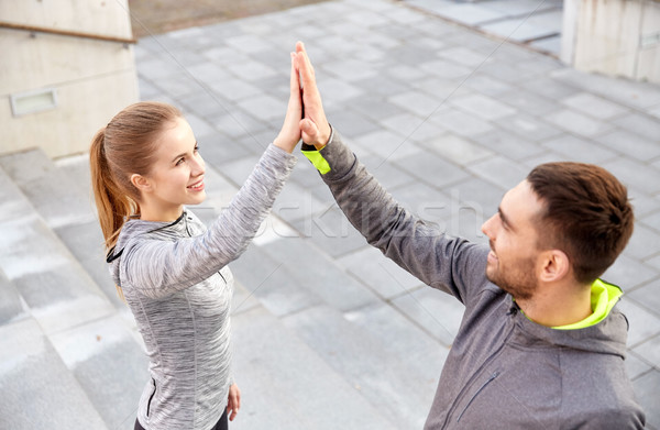 smiling couple making high five on city street Stock photo © dolgachov