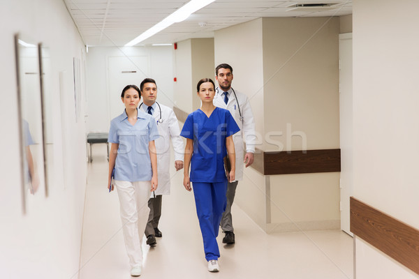 Stock photo: group of medics or doctors walking along hospital