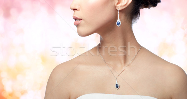 close up of woman with earring and pendant Stock photo © dolgachov