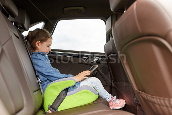 happy little girl with tablet pc driving in car Stock photo © dolgachov