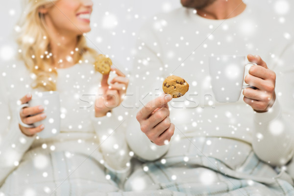 close up of happy couple with cookies and tea cups Stock photo © dolgachov