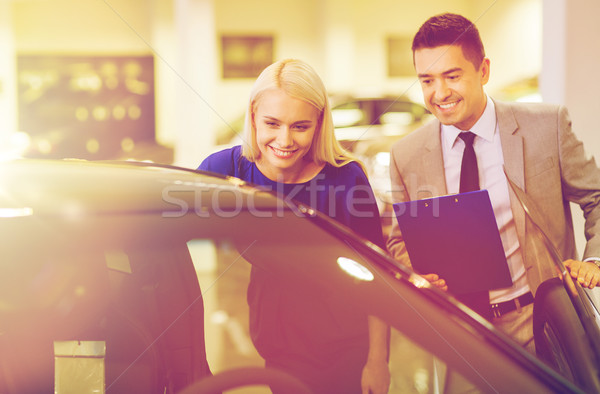 happy woman with car dealer in auto show or salon Stock photo © dolgachov
