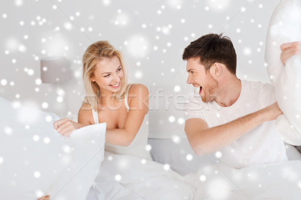 Heureux couple bataille d'oreillers lit maison personnes [[stock_photo]] © dolgachov