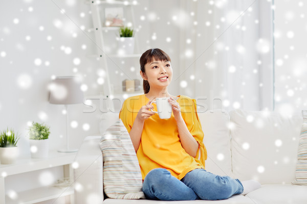 happy asian woman drinking from tea cup Stock photo © dolgachov