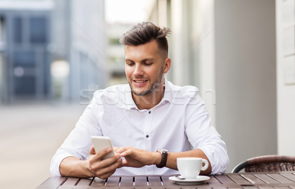 Stock photo: man with smartphone and coffee at city cafe