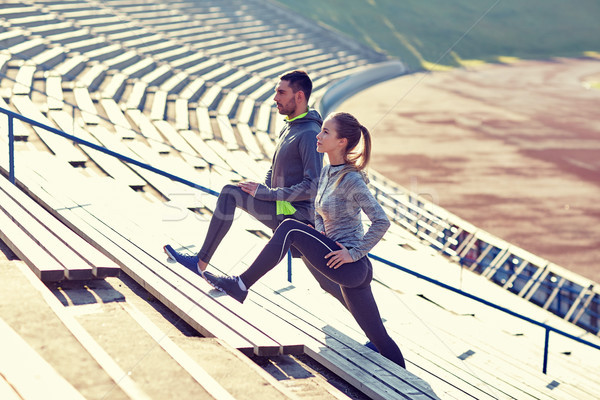 Stock photo: couple stretching leg on stands of stadium