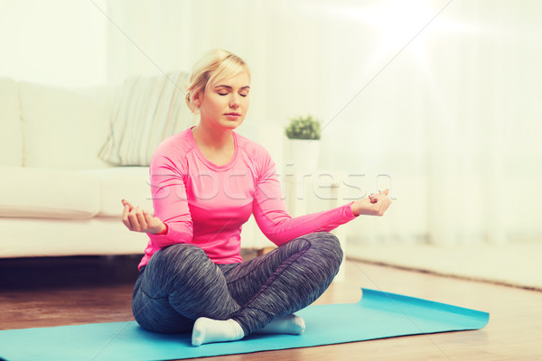 happy woman stretching leg on mat at home Stock photo © dolgachov