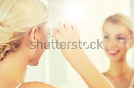 close up of woman applying face cream at bathroom Stock photo © dolgachov