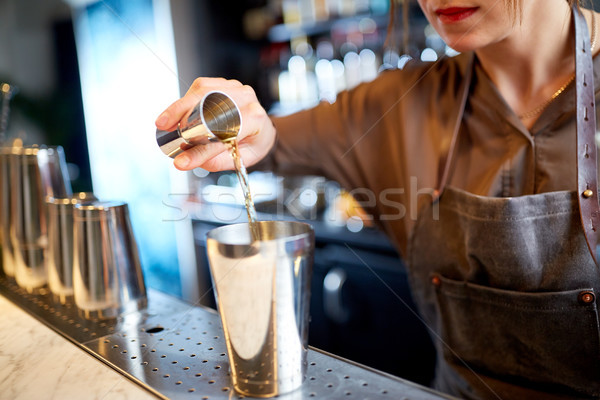 bartender with cocktail shaker and jigger at bar Stock photo © dolgachov