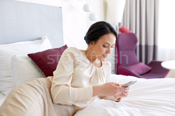 businesswoman with smartphone at hotel room Stock photo © dolgachov