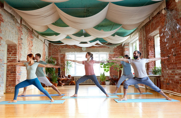 Foto stock: Grupo · de · personas · yoga · guerrero · plantean · estudio · fitness
