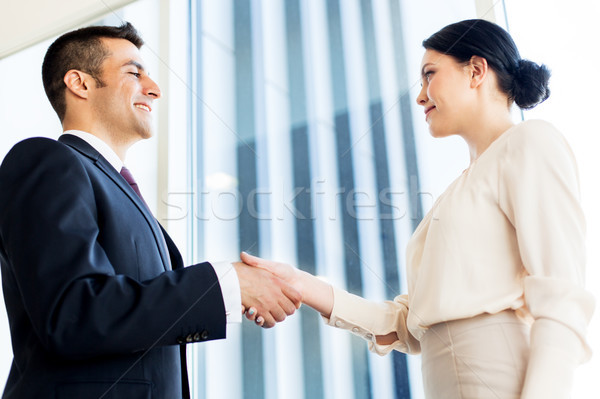 smiling business people shaking hands at office Stock photo © dolgachov