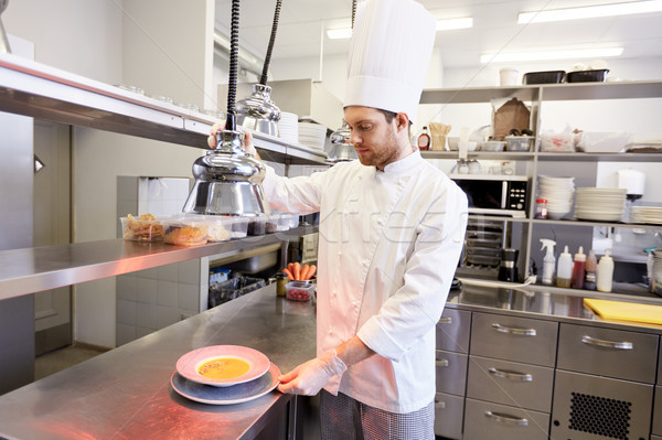 happy male chef cooking food at restaurant kitchen Stock photo © dolgachov