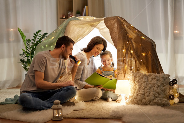 happy family reading book in kids tent at home Stock photo © dolgachov