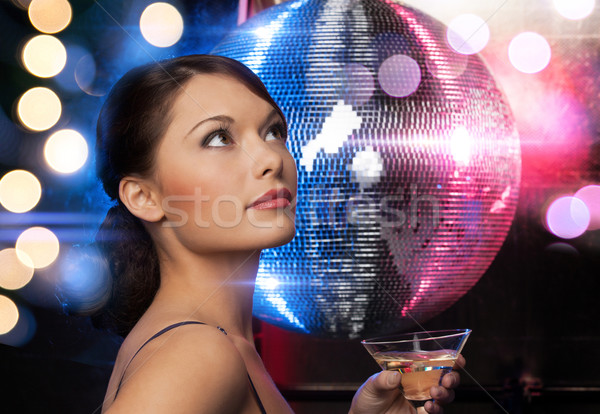 beautiful woman in evening dress with cocktail and disco ball