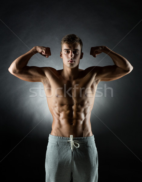 young man showing biceps Stock photo © dolgachov