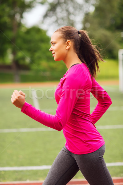 smiling woman running on track outdoors Stock photo © dolgachov