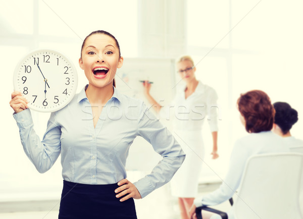 attractive businesswoman with wall clock Stock photo © dolgachov