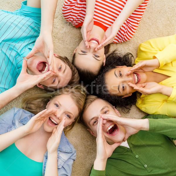 smiling people lying down on floor and screaming Stock photo © dolgachov