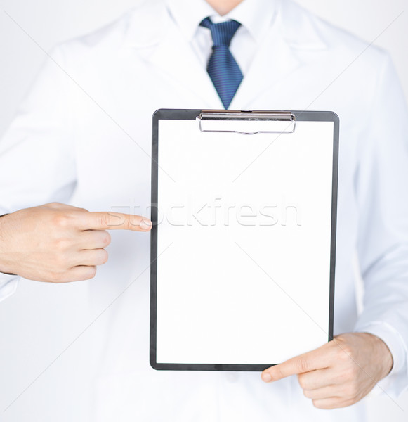 doctor pointing at blank white paper Stock photo © dolgachov