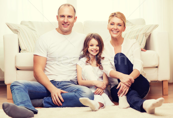 parents and little girl sitting on floor at home Stock photo © dolgachov