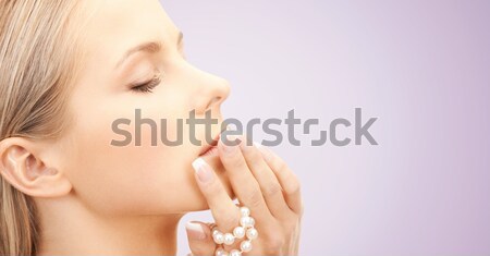 Stock photo: beautiful woman with sea pearl beads over blue