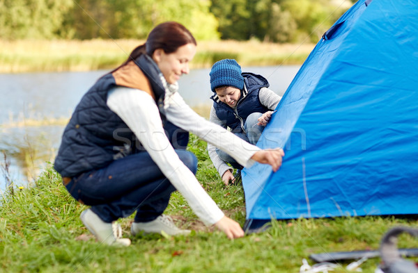 happy mother and son setting up tent outdoors Stock photo © dolgachov