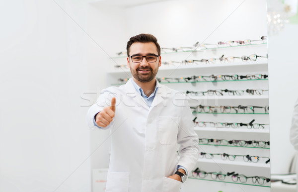 man with glasses and thumbs up at optics store Stock photo © dolgachov