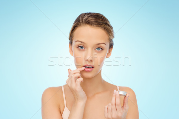 young woman applying lip balm to her lips Stock photo © dolgachov