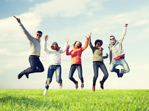 smiling friends in sunglasses jumping high Stock photo © dolgachov