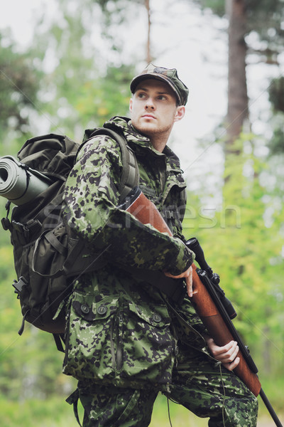 young soldier or hunter with gun in forest Stock photo © dolgachov