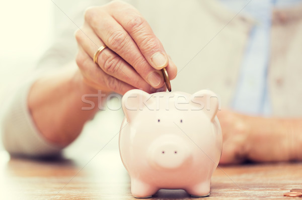 Senior mulher mão dinheiro piggy bank poupança Foto stock © dolgachov