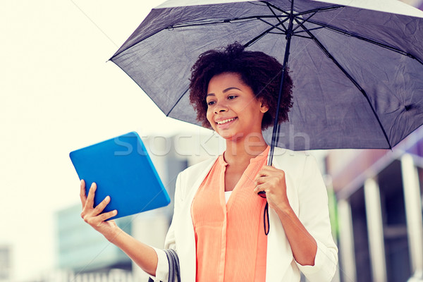 businesswoman with umbrella and tablet pc in city Stock photo © dolgachov