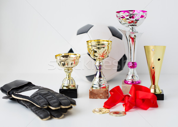 Stock photo: close up of football, gloves, cups and medals