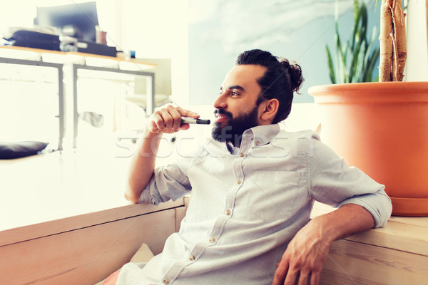smiling man with beard and hair bun at office Stock photo © dolgachov