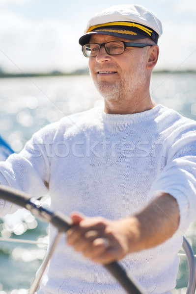 senior man at helm on boat or yacht sailing in sea Stock photo © dolgachov